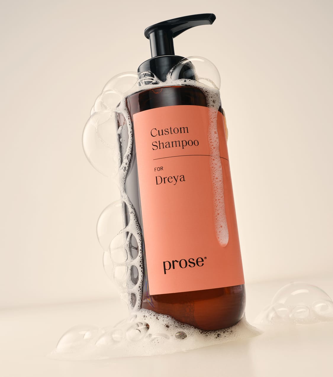 A-Prose-Custom-Shampoo-bottle-labeled-for-Dreya-covered-in-foam-and-surrounded-by-bubbles.jpg